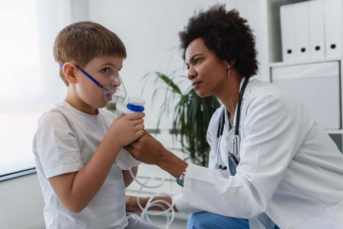 Niño con asma infantil siendo atendido por un médico. 