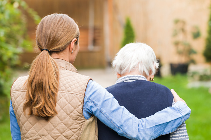 Mujer abrazando a persona mayor con Alzheimer.