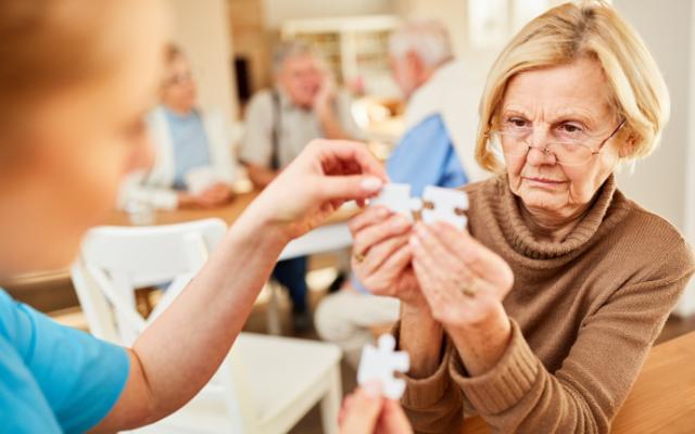 Mujer mayor haciendo un puzle para ver las diferencias entre demencia y Alzheimer.