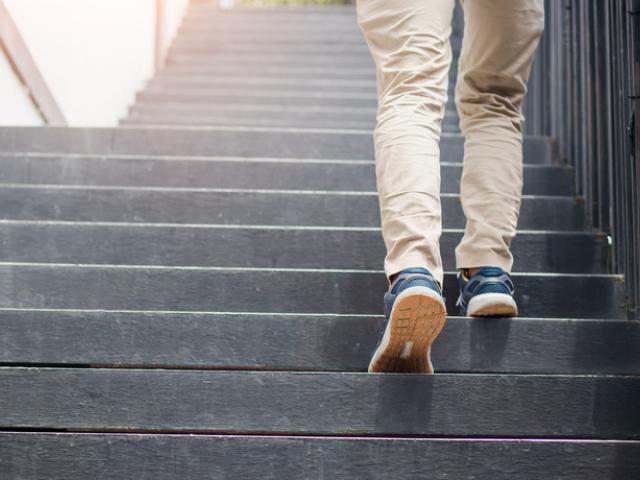 Piernas de un hombre subiendo escaleras